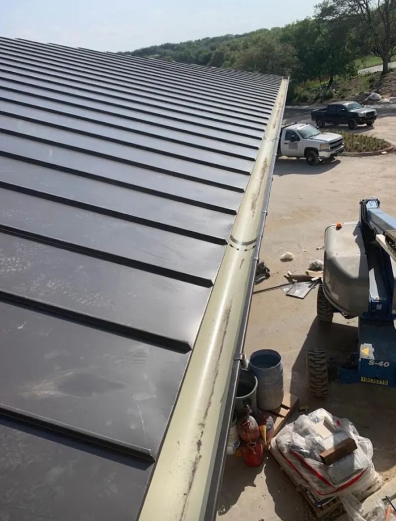 Standing seam panel and gutter detail on a metal roofing jobsite in Crookston